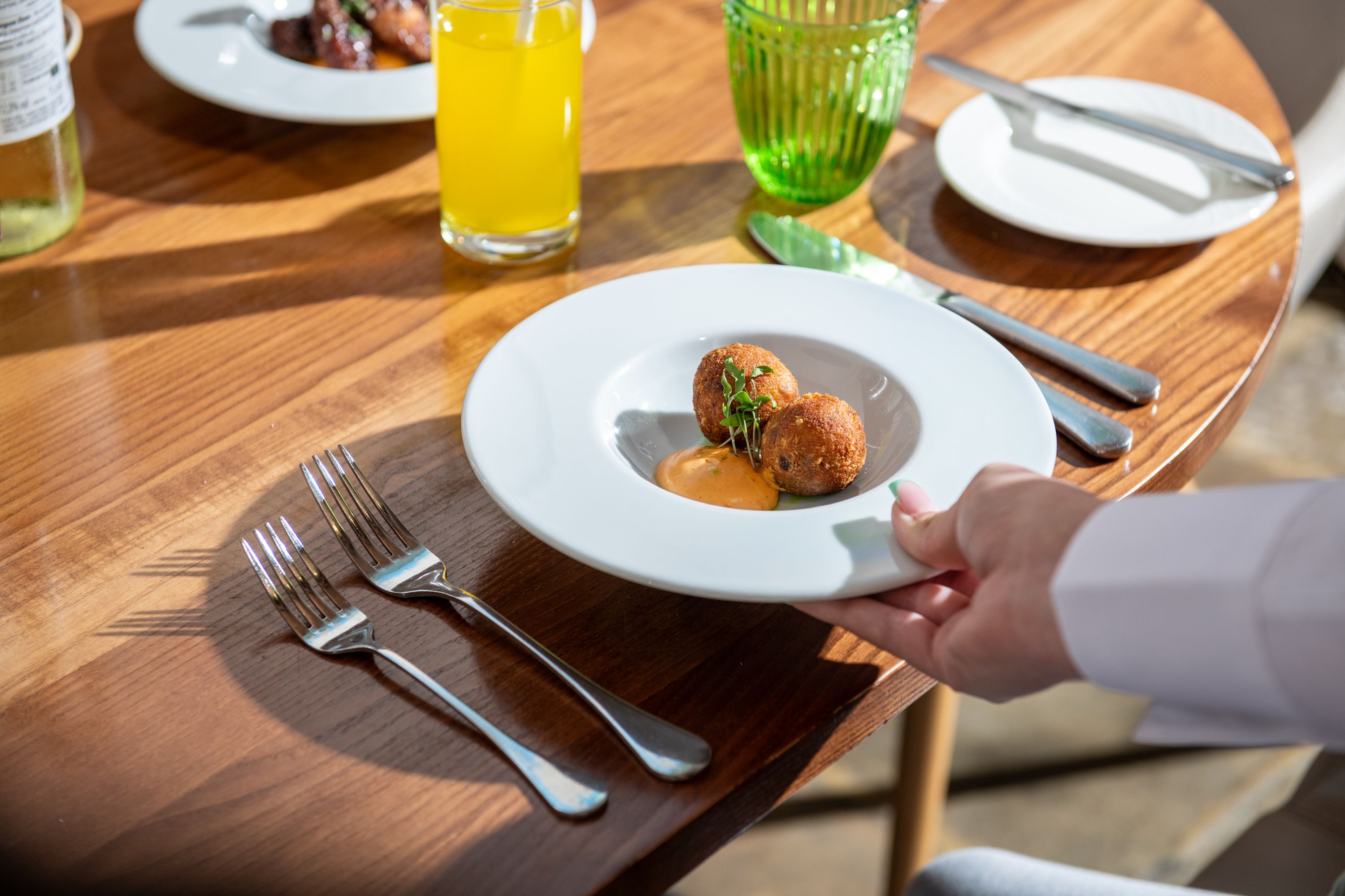 Plate of breaded food being placed on a table
